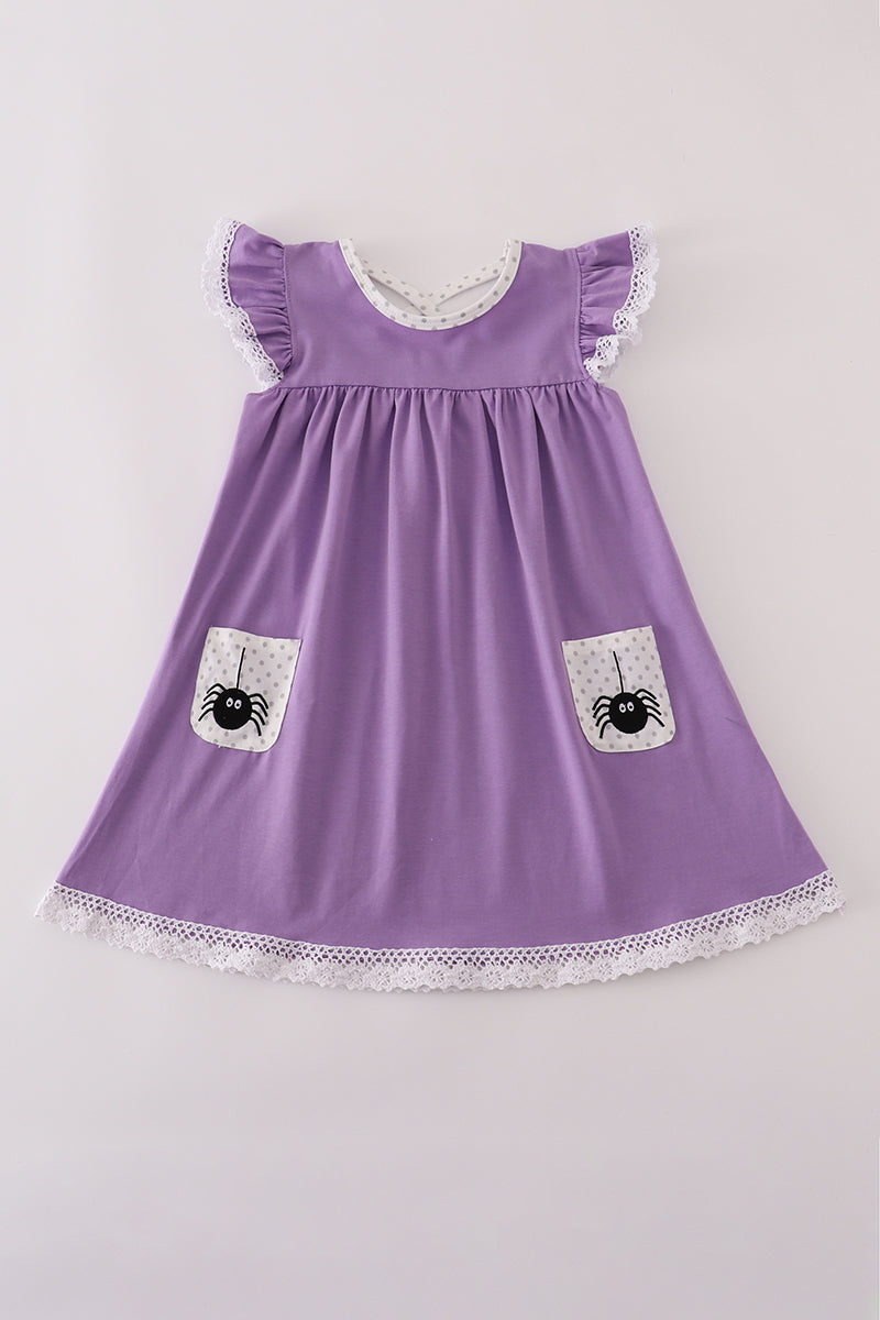 Purple dress with spider pockets on a light gray background