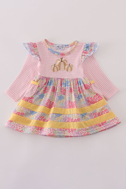 Children's dress with floral skirt and pink checkered top on a light gray background