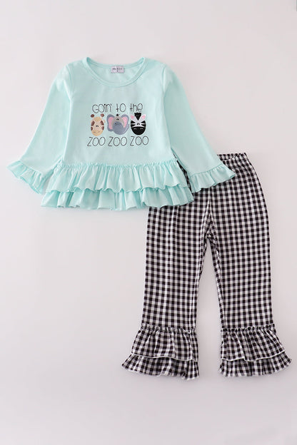 Children's outfit with light blue top and checkered pants on a white background