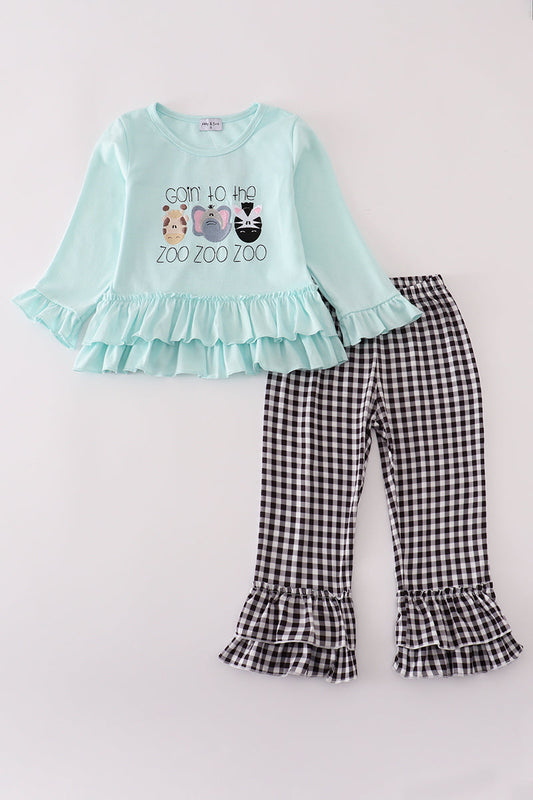 Children's outfit with light blue top and checkered pants on a white background