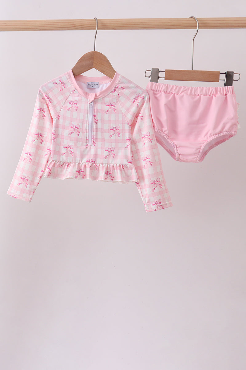 Pink children's outfit with a jacket and shorts on hangers against a white background