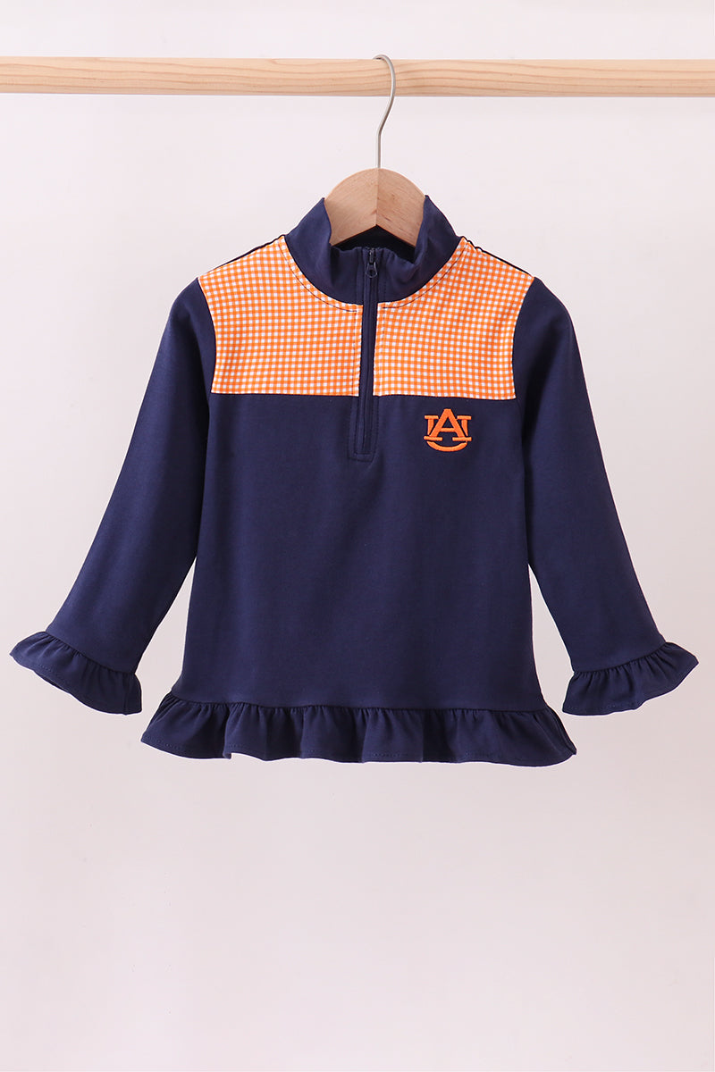 Navy blue dress with orange checkered collar and logo on a wooden hanger against a white background