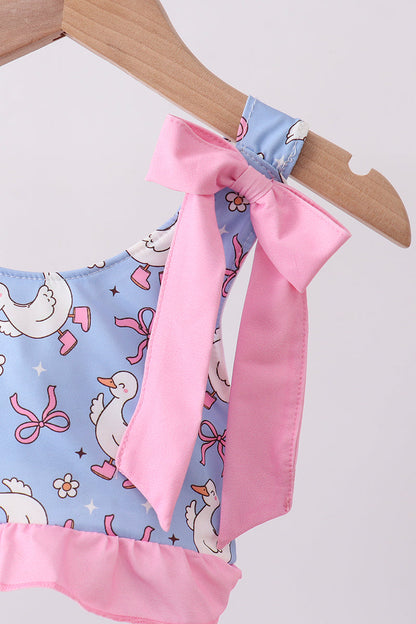 Children's outfit with pink bow and duck pattern on a hanger