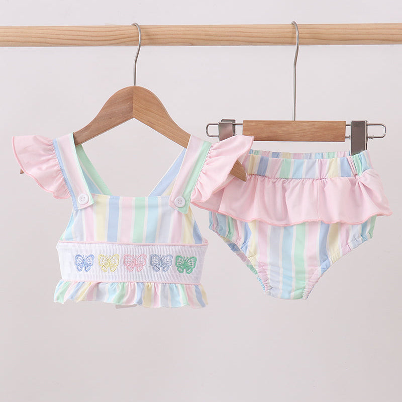Children's clothing. Rainbow Stripe Butterfly Smocked Ruffle 2-Piece Girls Swimsuit. Vibrant rainbow stripes, delicate butterfly details, a flattering smocked bodice, and playful ruffled trim make this set as joyful and fun as a summer day at the beach
