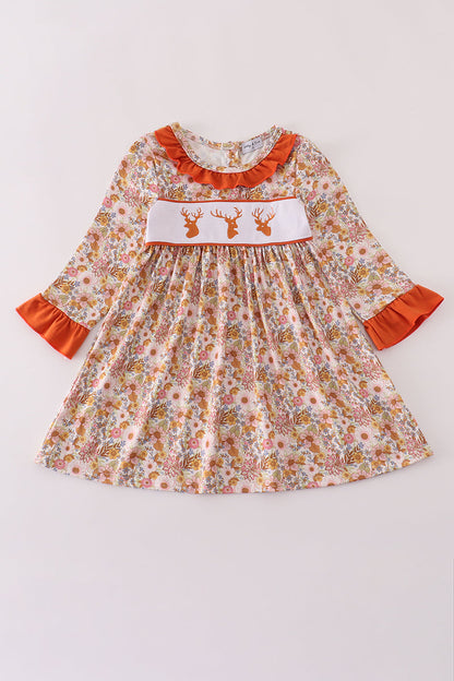 Floral dress with orange accents on a white background