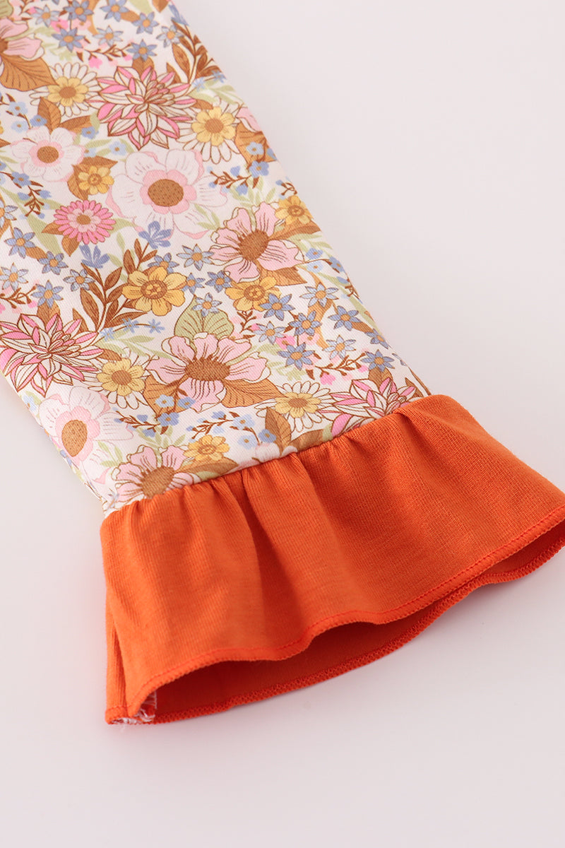 Floral fabric with orange ruffle on a white background